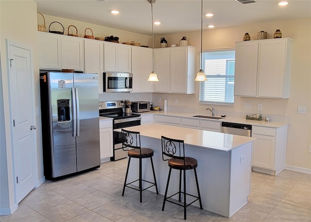 kitchen featuring sink, stainless steel appliances, white cabinets, and a kitchen island