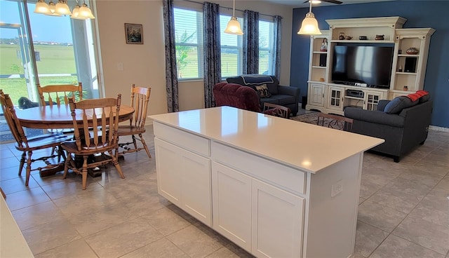 kitchen with white cabinetry, a center island, a notable chandelier, and decorative light fixtures