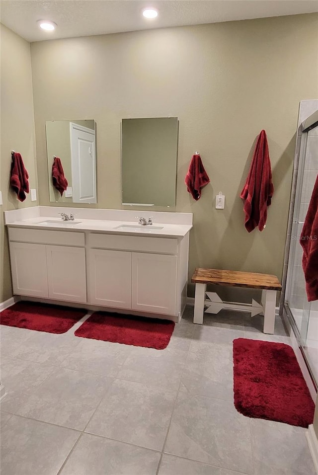 bathroom featuring vanity, a shower with shower door, and a textured ceiling