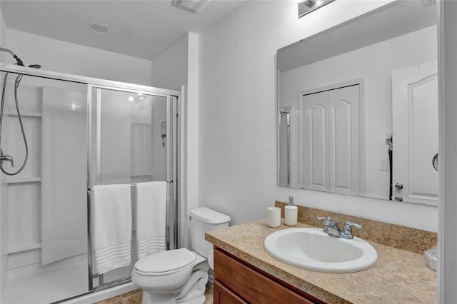 bathroom featuring vanity, toilet, and a shower with door