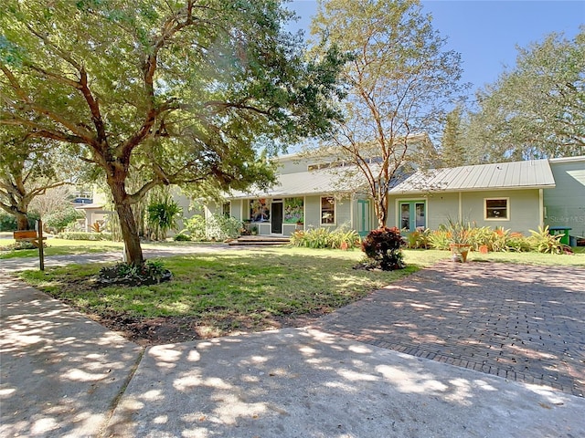 ranch-style home featuring a front yard and french doors