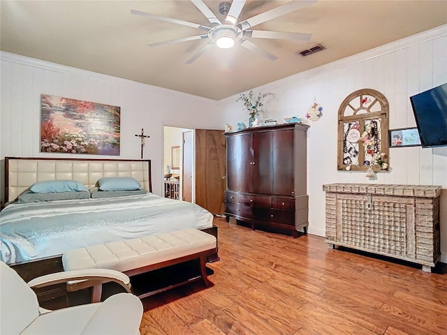 bedroom featuring crown molding, light hardwood / wood-style flooring, and ceiling fan