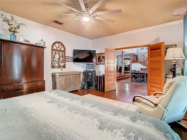 bedroom featuring hardwood / wood-style flooring, ornamental molding, and a textured ceiling