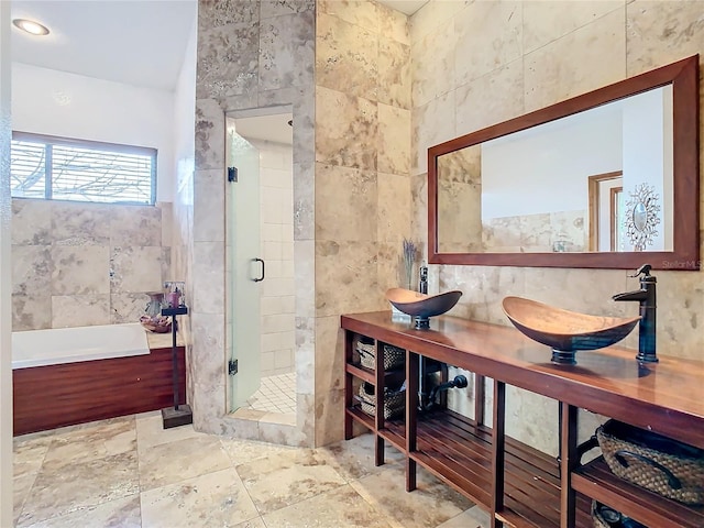 bathroom featuring tile walls, vanity, and shower with separate bathtub