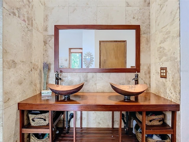 bathroom with tile walls, vanity, and decorative backsplash