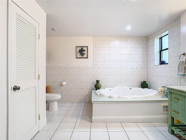 bathroom featuring tile patterned floors, toilet, a bathing tub, and tile walls