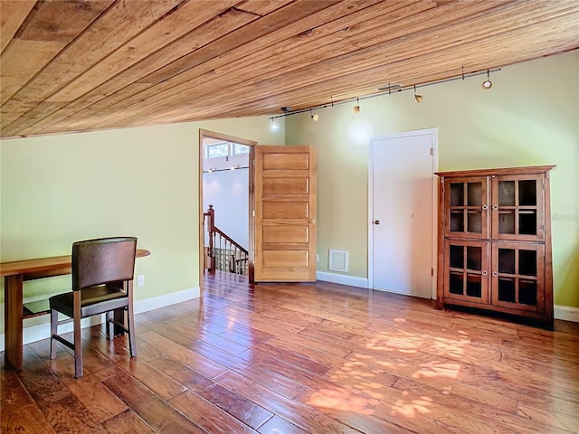 unfurnished room with rail lighting, hardwood / wood-style floors, and wooden ceiling