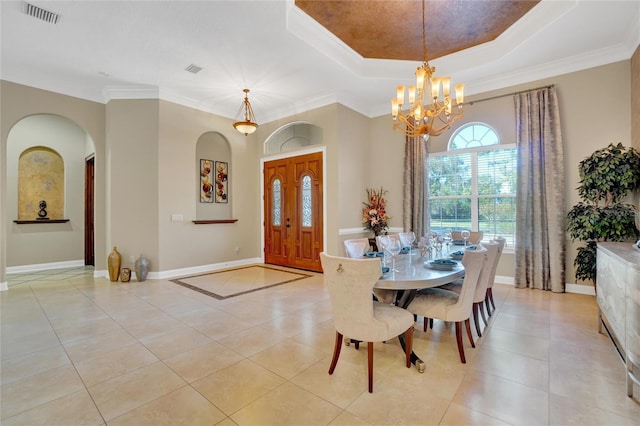 dining area featuring an inviting chandelier, ornamental molding, a tray ceiling, and light tile patterned floors