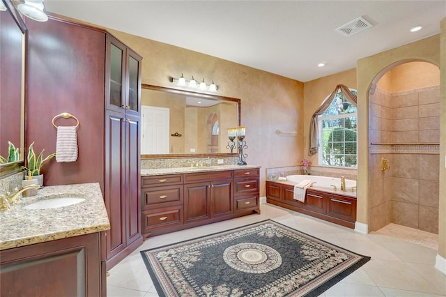 bathroom featuring a bathing tub, tile patterned floors, and vanity