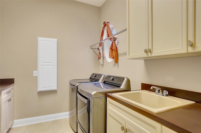 laundry room featuring washer and dryer, sink, light tile patterned floors, and cabinets