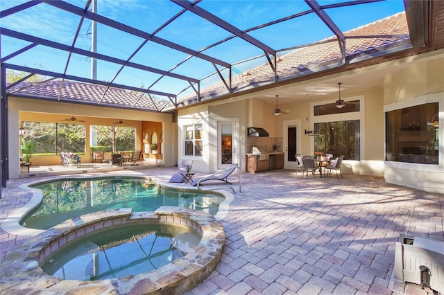 view of pool featuring a patio, an outdoor kitchen, an in ground hot tub, a lanai, and ceiling fan