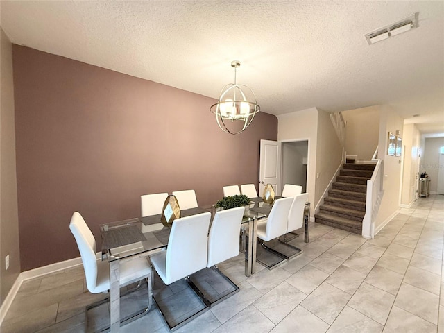 dining area with a textured ceiling and a chandelier