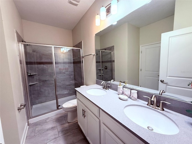 bathroom featuring vanity, an enclosed shower, a textured ceiling, and toilet