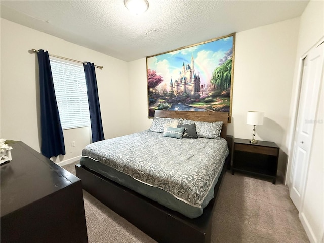 bedroom featuring a textured ceiling and carpet flooring