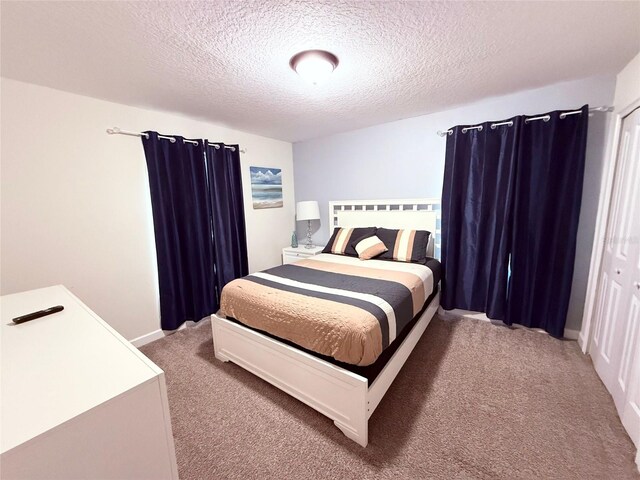 bedroom featuring carpet and a textured ceiling