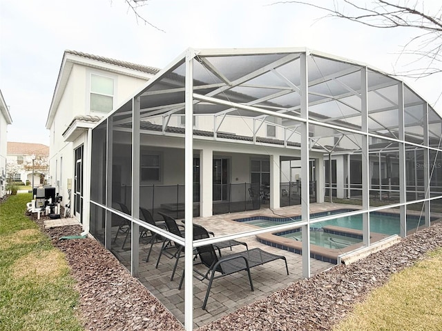 back of house featuring a swimming pool with hot tub and a patio