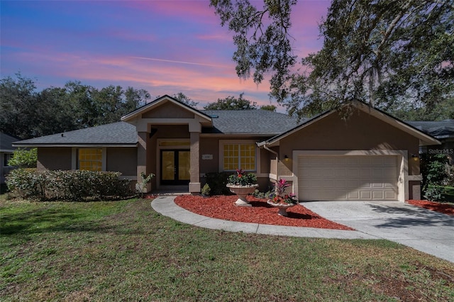 ranch-style home featuring a garage and a lawn