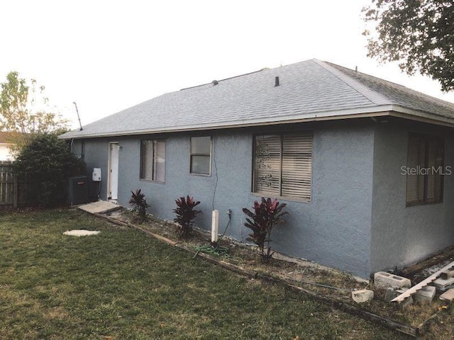 view of side of home featuring a lawn and central air condition unit