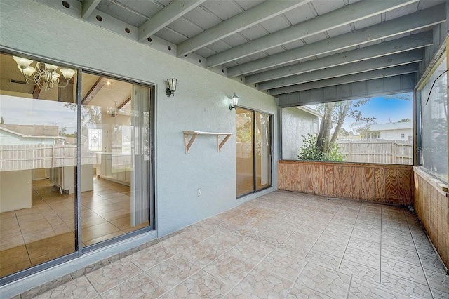 unfurnished sunroom with beam ceiling