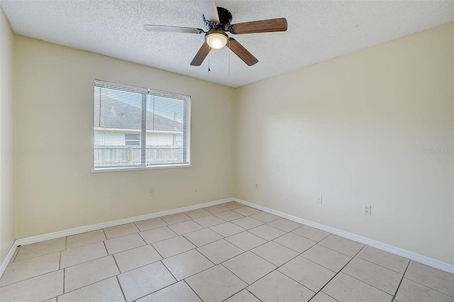 tiled empty room with ceiling fan and a textured ceiling