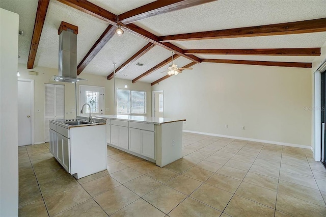 kitchen featuring sink, white cabinetry, lofted ceiling with beams, a textured ceiling, and a kitchen island with sink