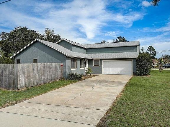 single story home with a garage and a front yard