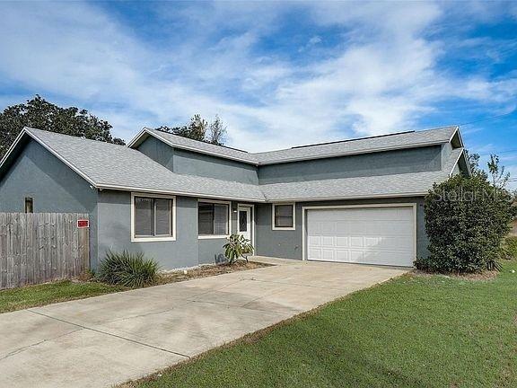 ranch-style house featuring a garage and a front yard