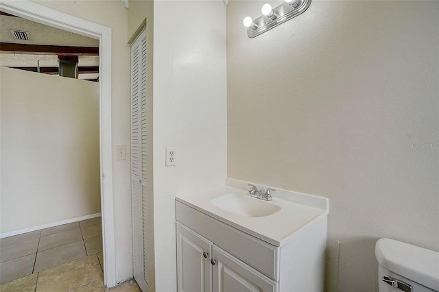 bathroom featuring tile patterned flooring, vanity, and toilet