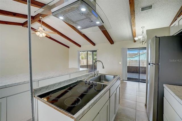 kitchen with stainless steel refrigerator, vaulted ceiling with beams, sink, white cabinets, and black electric stovetop