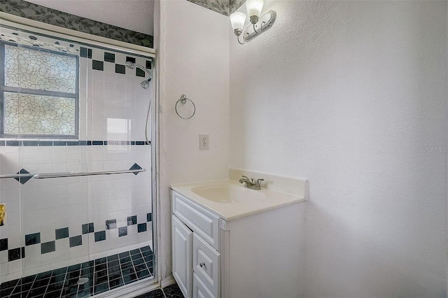 bathroom with vanity and a tile shower