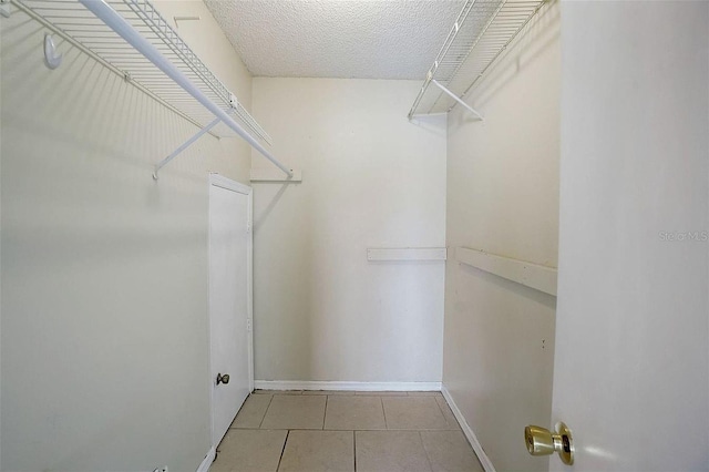 walk in closet with light tile patterned floors