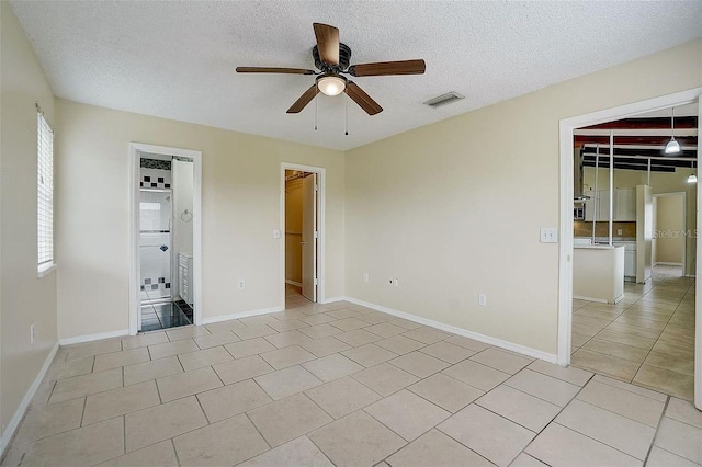 tiled spare room featuring ceiling fan and a textured ceiling