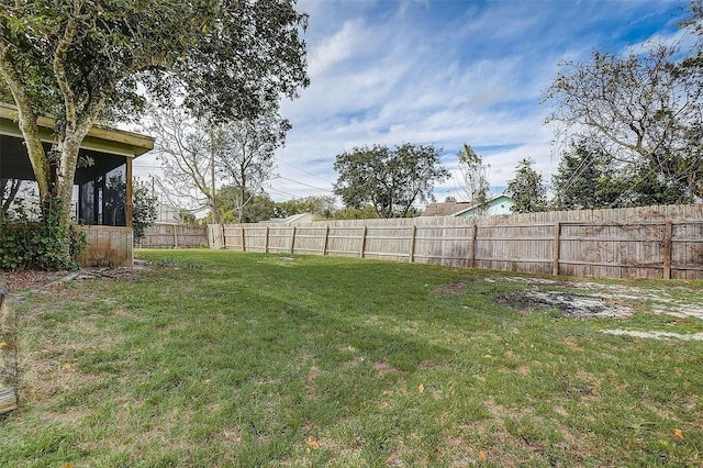 view of yard with a sunroom and a fenced backyard