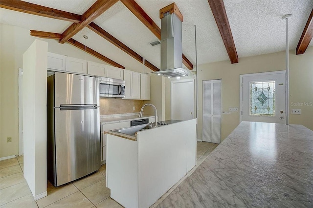 kitchen with island exhaust hood, a center island with sink, stainless steel appliances, white cabinets, and vaulted ceiling with beams