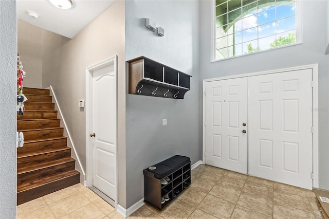 tiled entrance foyer featuring a high ceiling