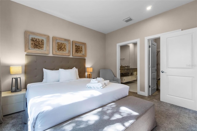 bedroom featuring connected bathroom, a spacious closet, and carpet