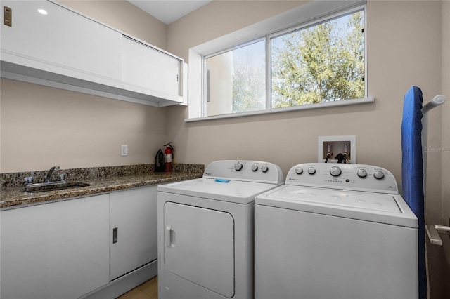 washroom featuring cabinets, sink, and washing machine and dryer