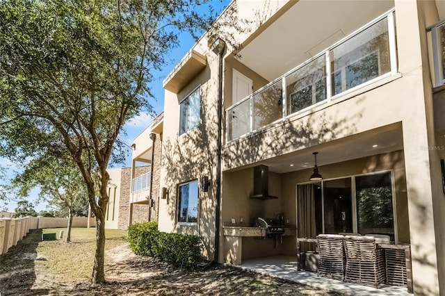 back of property featuring a patio and an outdoor kitchen