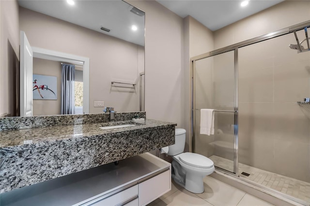 bathroom featuring walk in shower, vanity, toilet, and tile patterned flooring