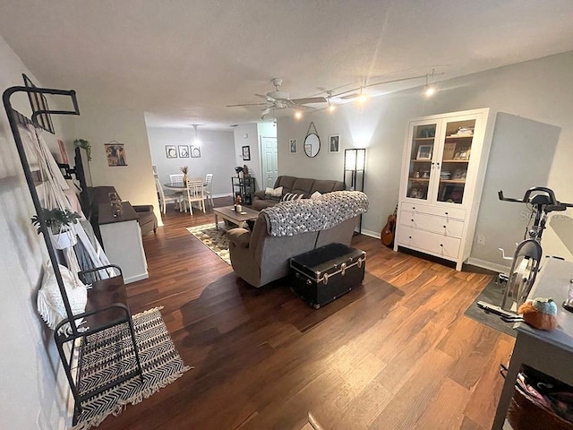 living room with dark wood-type flooring and ceiling fan