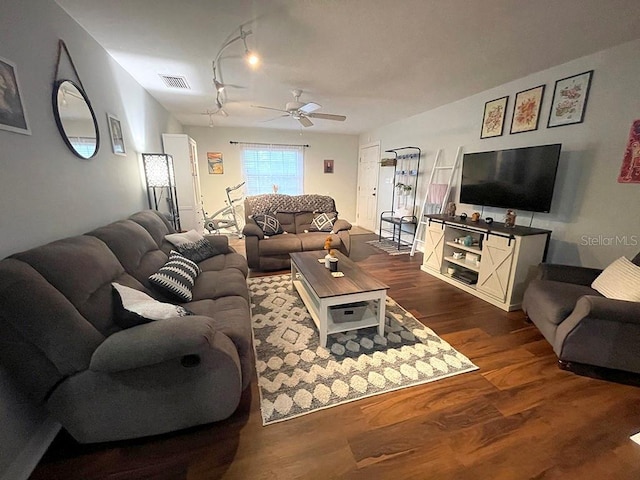 living room featuring dark wood-type flooring and ceiling fan