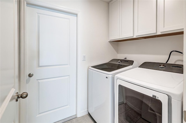 clothes washing area with cabinets, light tile patterned flooring, and separate washer and dryer