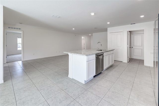 kitchen featuring sink, light stone counters, stainless steel dishwasher, an island with sink, and white cabinets