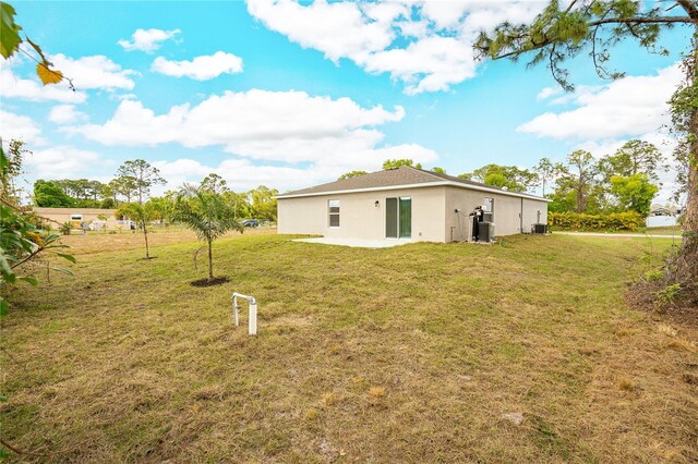 rear view of property featuring a patio and a yard