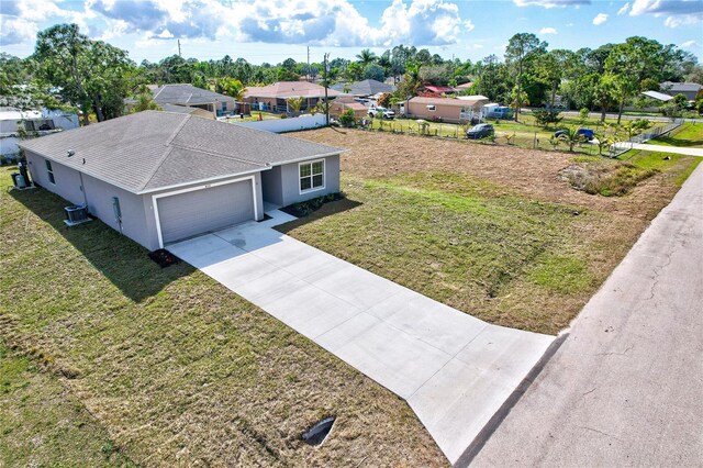 view of front of property featuring a garage, a front yard, and central air condition unit