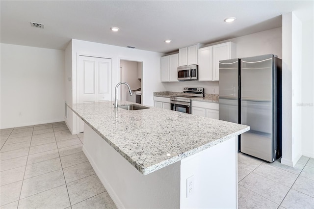 kitchen featuring sink, stainless steel appliances, an island with sink, and white cabinets