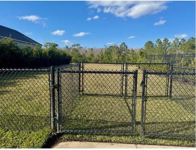 view of gate with a lawn