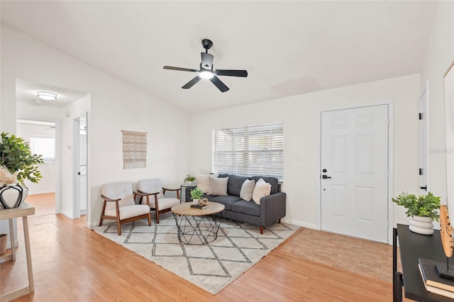 living room featuring lofted ceiling, light hardwood / wood-style flooring, and plenty of natural light