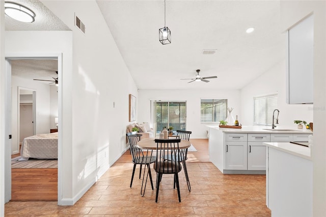 dining space with sink, ceiling fan, and light wood-type flooring