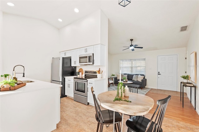 kitchen featuring sink, white cabinets, ceiling fan, stainless steel appliances, and light hardwood / wood-style flooring